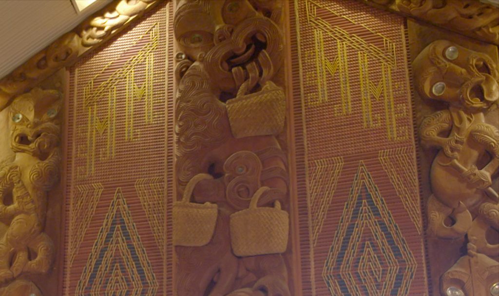 The story from Maori mythology of the three baskets of knowledge is depicted in a carving beside the entrance to the marae.